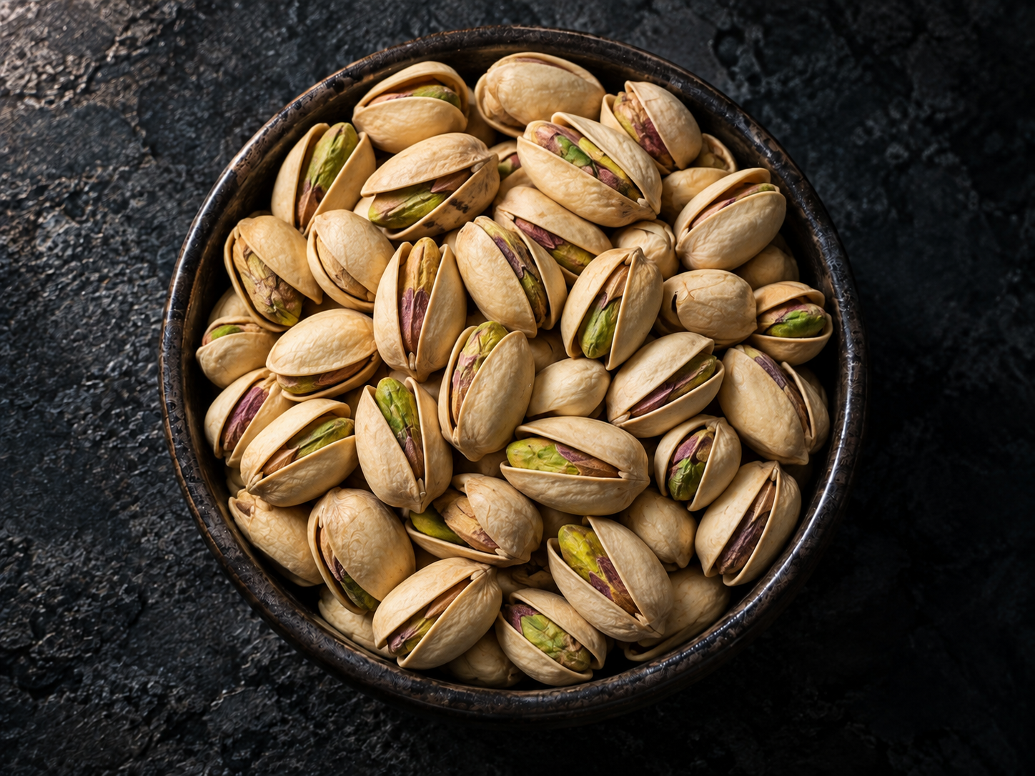 Pistachios in a dark bowl
