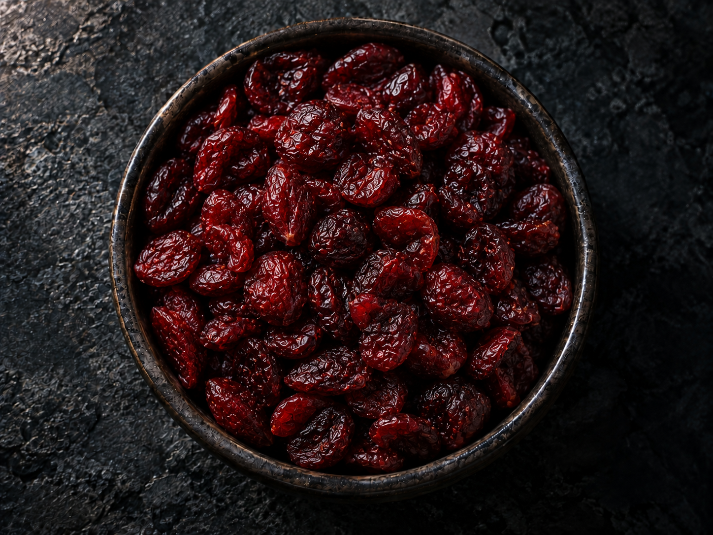 Sweetened dried cranberries in a dark bowl
